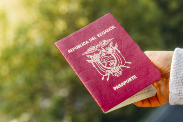 Pasaporte de Ecuador sostenido con la mano, en primer plano.