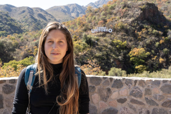 Mujer con mochila frente al Cerro Uritorco, en Córdoba, Argentina.