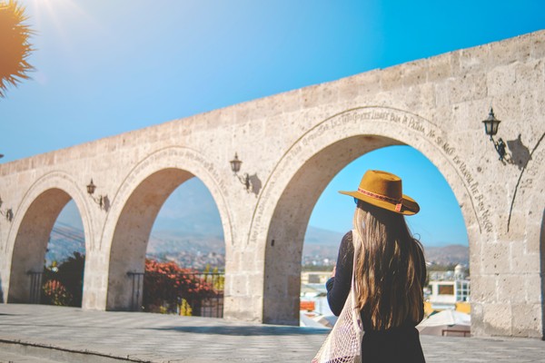 Turista con sombrero y cabello largo en el mirador Yamahuara, Arequipa, Perú.