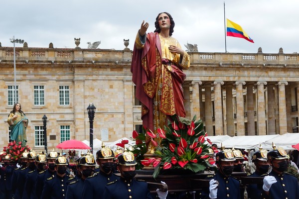 Procesión de Viernes Santo en Bogotá con bandera colombiana de fondo.