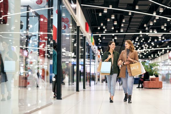 Mujeres con bolsas de compras caminando por un shopping.