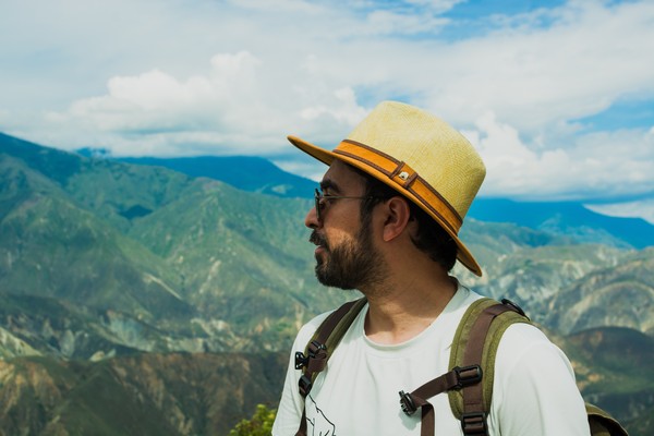 Hombre latino de pie en el mirador de Panachi, con vistas a los espectaculares paisajes del cañón de Chicamocha en Colombia.