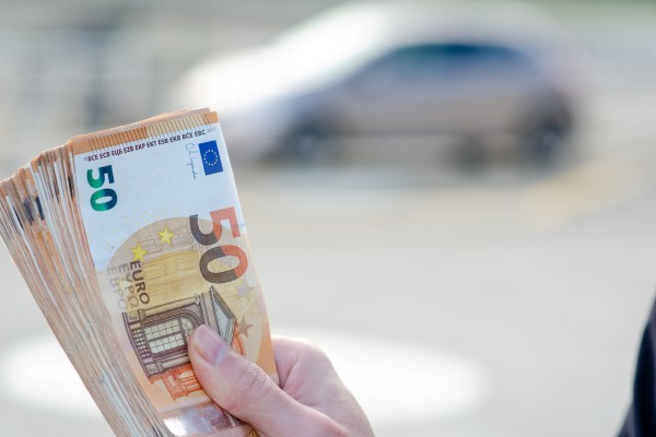 Personas sosteniendo billetes de 50 euros.