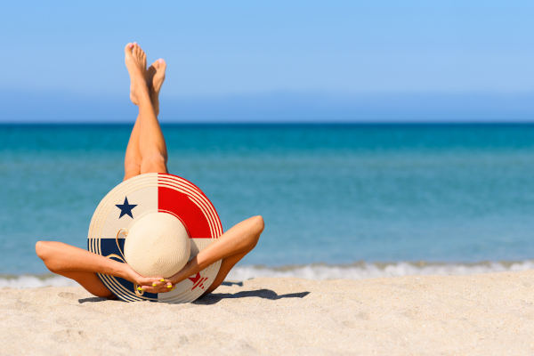 Una muchacha delgada en la playa con un sombrero de paja en los colores de la bandera de Panamá.