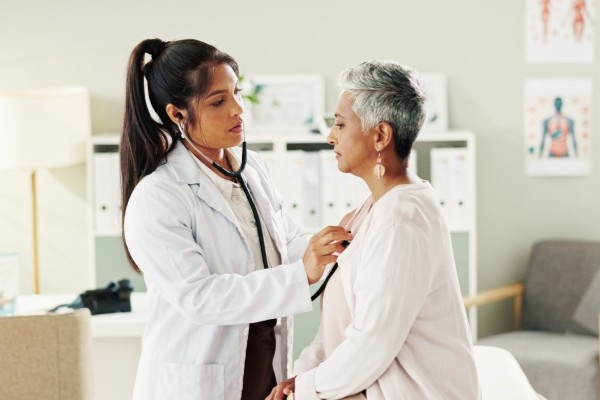Mujer con seguro de viajero siendo atendida por una doctora.