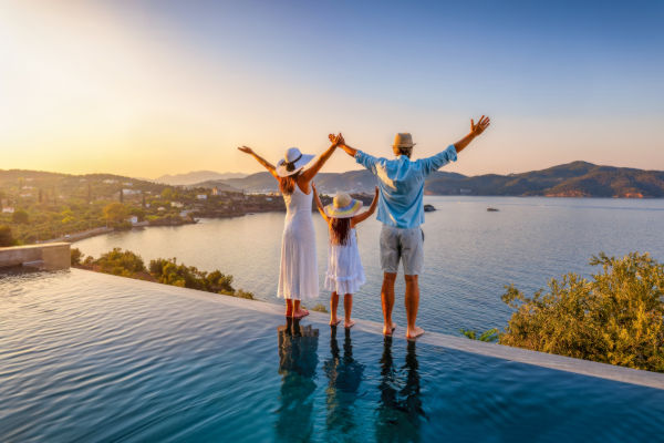 Familia disfrutando de una vista panorámica al mar desde una piscina.