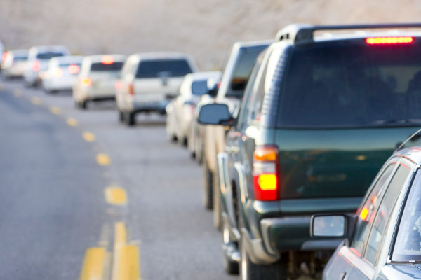 Coches en fila en una carretera irreconocible de Arizona, Estados Unidos. Tránsito vehicular en la frontera.
