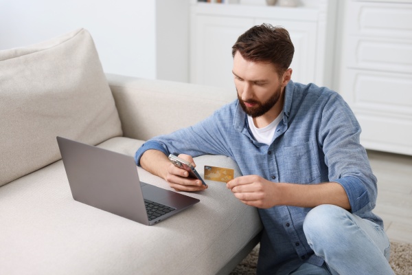 Joven mexicano que realiza el pago de la visa Turquía con su celular y laptop.