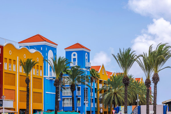Edificio del Renaissance Mall rodeado de palmeras en Willemstad, Curazao, en un día soleado.