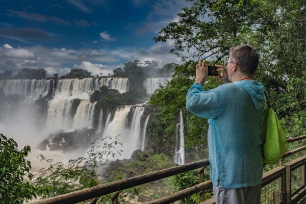 Hombre saca fotos de las Cataratas del Iguazú con su celular.