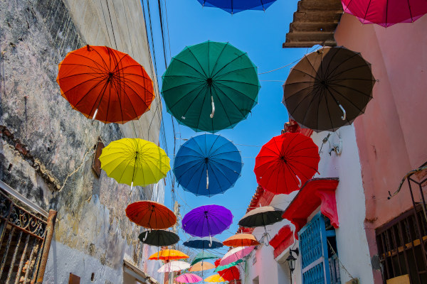 Paraguas coloridos decorativos en una calle de Cartagena en un día soleado.
