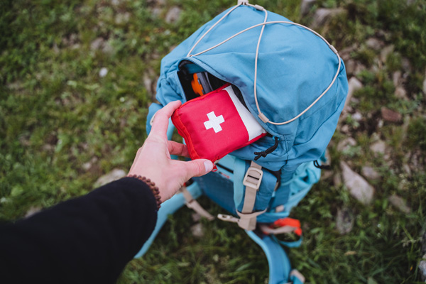 Mano sosteniendo mochila con botiquín