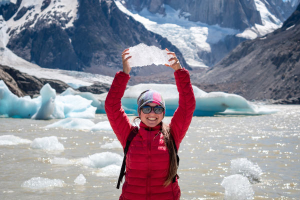 Turista en Laguna Torre con un trozo de glaciar en sus manos,  El Chalten, Argentina.