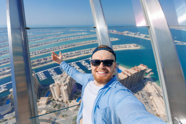 Joven turista se toma una selfie en rascacielos de  Dubai.