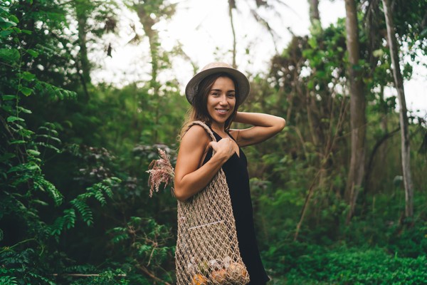 Mujer turista posando para la cámara en una zona cálida y boscosa.