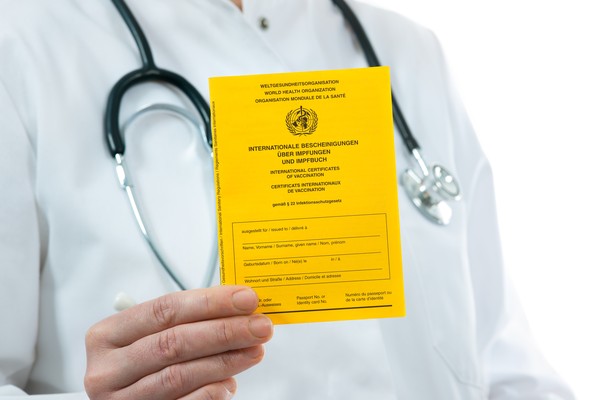 Doctor que sostiene un certificado internacional de vacuna contra la fiebre amarilla