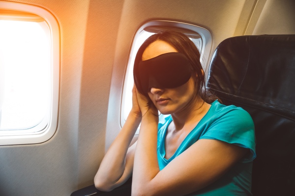Mujer con jet lag que duerme en el avión.