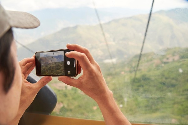 Persona tomando fotos del metrocable en Medellín, Colombia.
