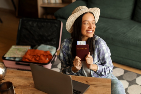 Mujer que contrata el mejor seguro de viaje en su laptop antes de viajar.