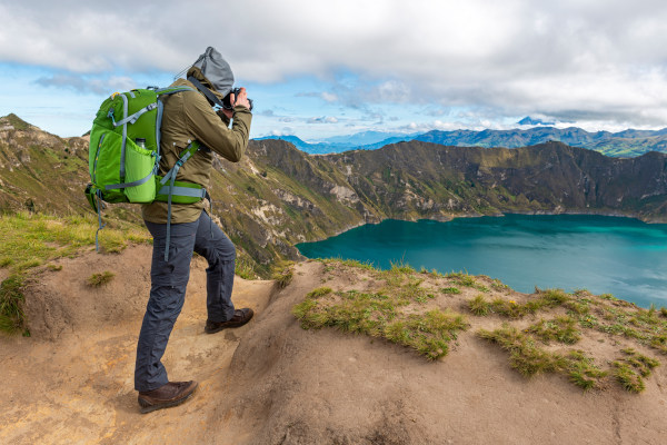 Mochilero fotografiando la Laguna de Quilotoa en Ecuador.