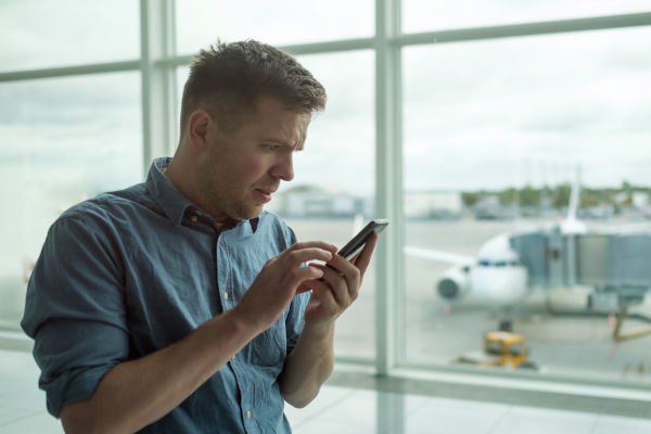Hombre en aeropuerto resolviendo un trámite antes de viajar.