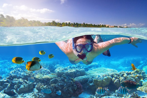 Mujer haciendo snorkel en aguas poco profundas del mar Caribe mexicano.