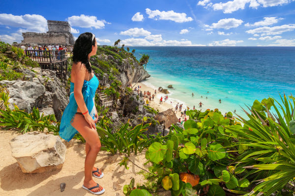 Mujer turista con vista panorámica de una playa de Tulum en el mar Caribe, México