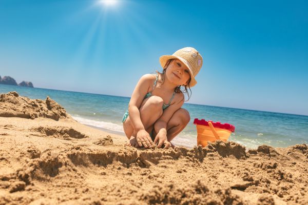Niña feliz armando un castillo de arena en una de las playas de Panamá.