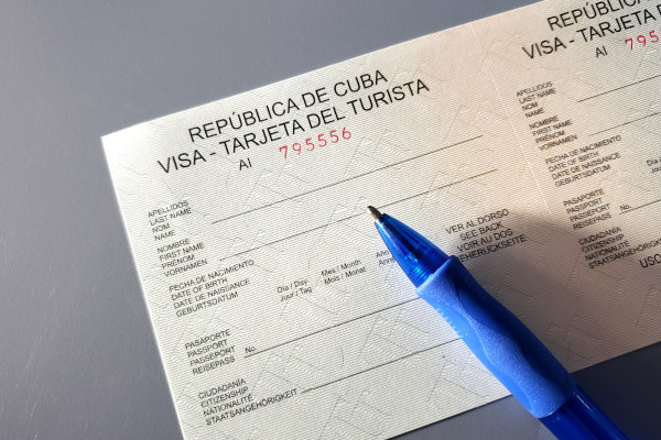 Imagen de la tarjeta del turista de la República de Cuba junto con un bolígrafo azul.