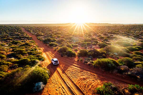 Paisaje desértico con una carretera de tierra roja en Australia