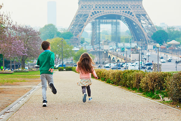 Niños corriendo cerca de la Torre Eiffel