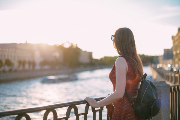 Mujer turista que cumple los requisitos para viajar a Suecia desde Perú, mirando hacia el río de la ciudad.