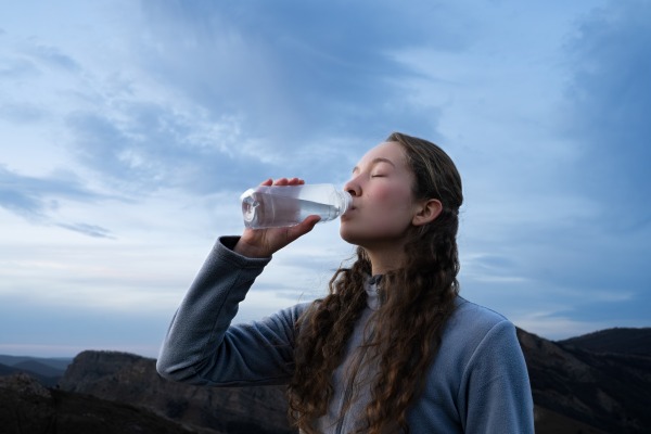 Mujer que se hidrata para prevenir los síntomas del soroche