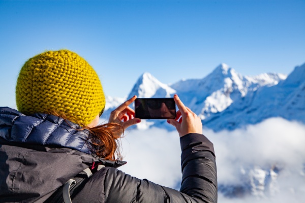 Mujer saca fotos de los Alpes suizos con su celular.