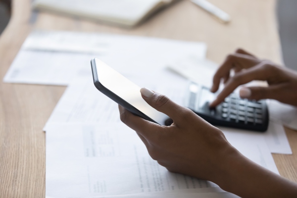 Persona calculando cuánto sale un seguro médico de viaje en la web de Assist Card desde su celular.