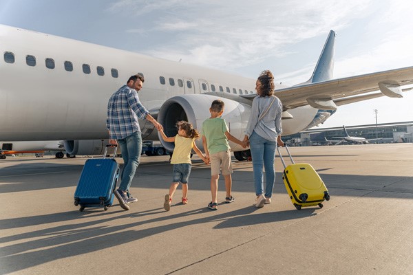 Familia con maletas acercándose a avión