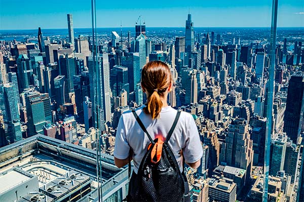 Una mujer viendo desde una torre la ciudad de Nueva York