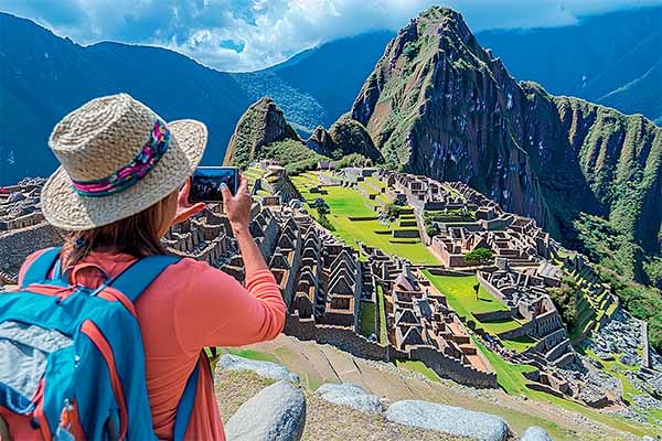 Una mujer turista fotografiando a las ruinas de Machu Picchu