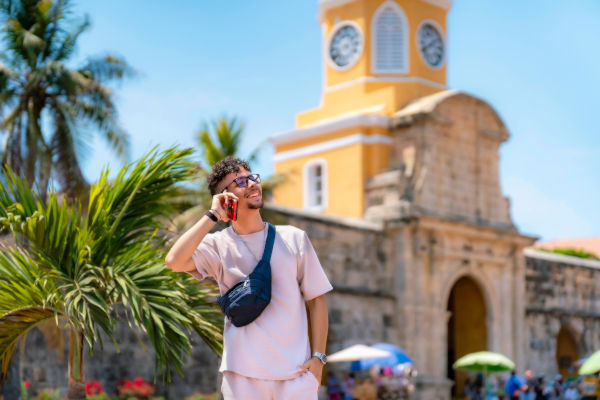 Turista hablando por teléfono frente a la Torre del Reloj en Cartagena de Indias, Colombia.