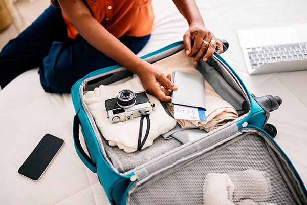 Mujer empacando documentos para viajar