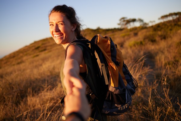Mujer sonriente haciendo senderismo en la naturaleza.
