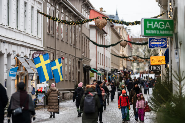 Personas abrigadas caminando por una calle en Suiza durante un día frío.